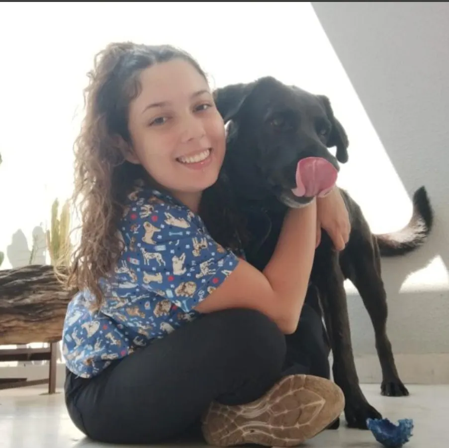 Dra. Vanessa abraçada a um labrador preto
